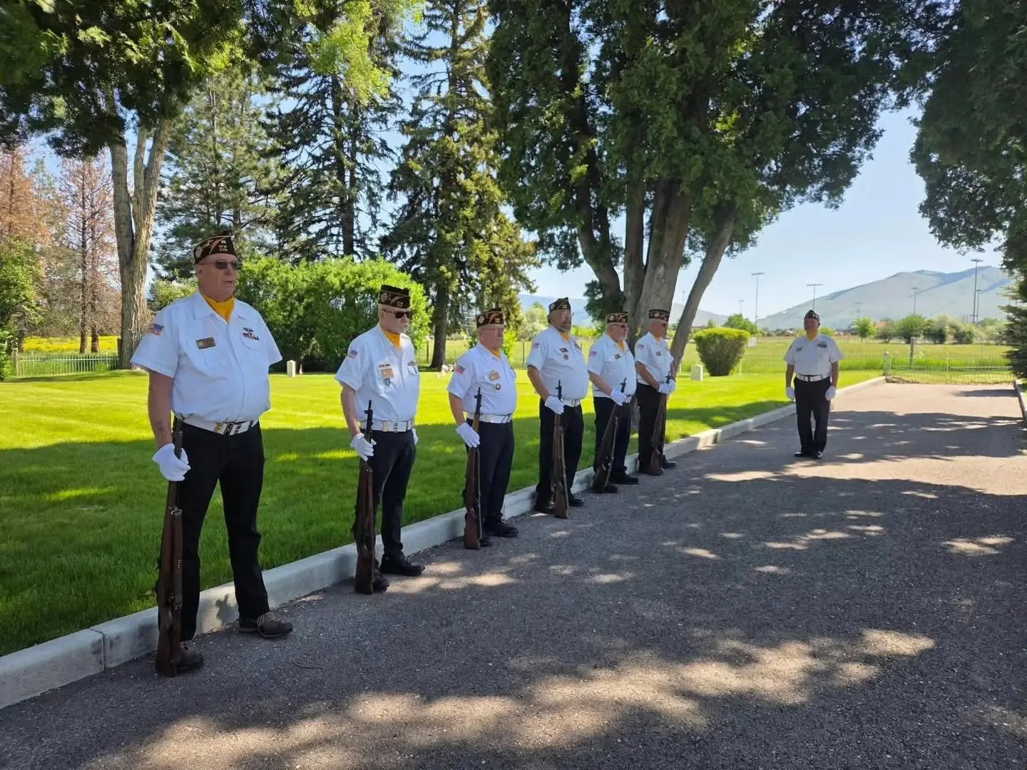A group of men in uniform stands in formation outdoors.