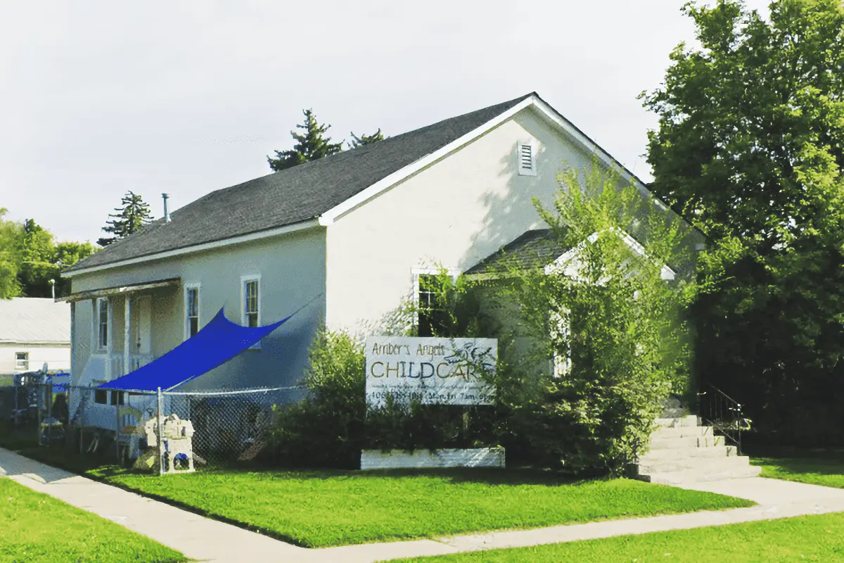 A childcare facility building with a sign in front.
