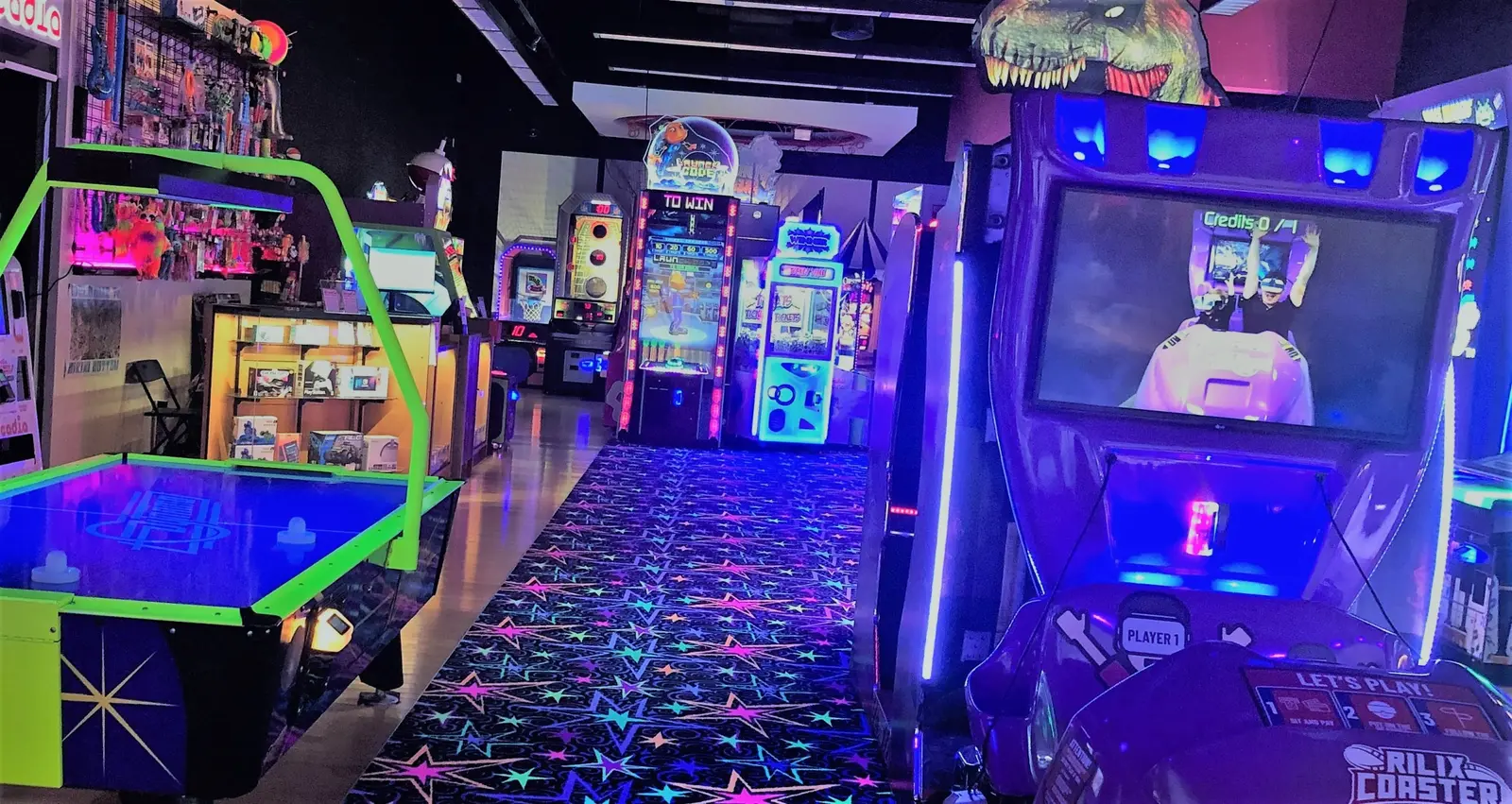 An arcade interior features various gaming machines and a vibrant star-patterned carpet.