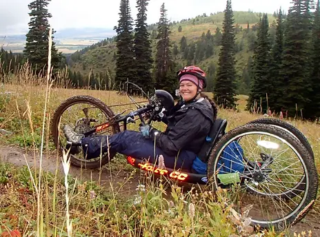 Picture of woman using a hand bike in beautiful mountain setting