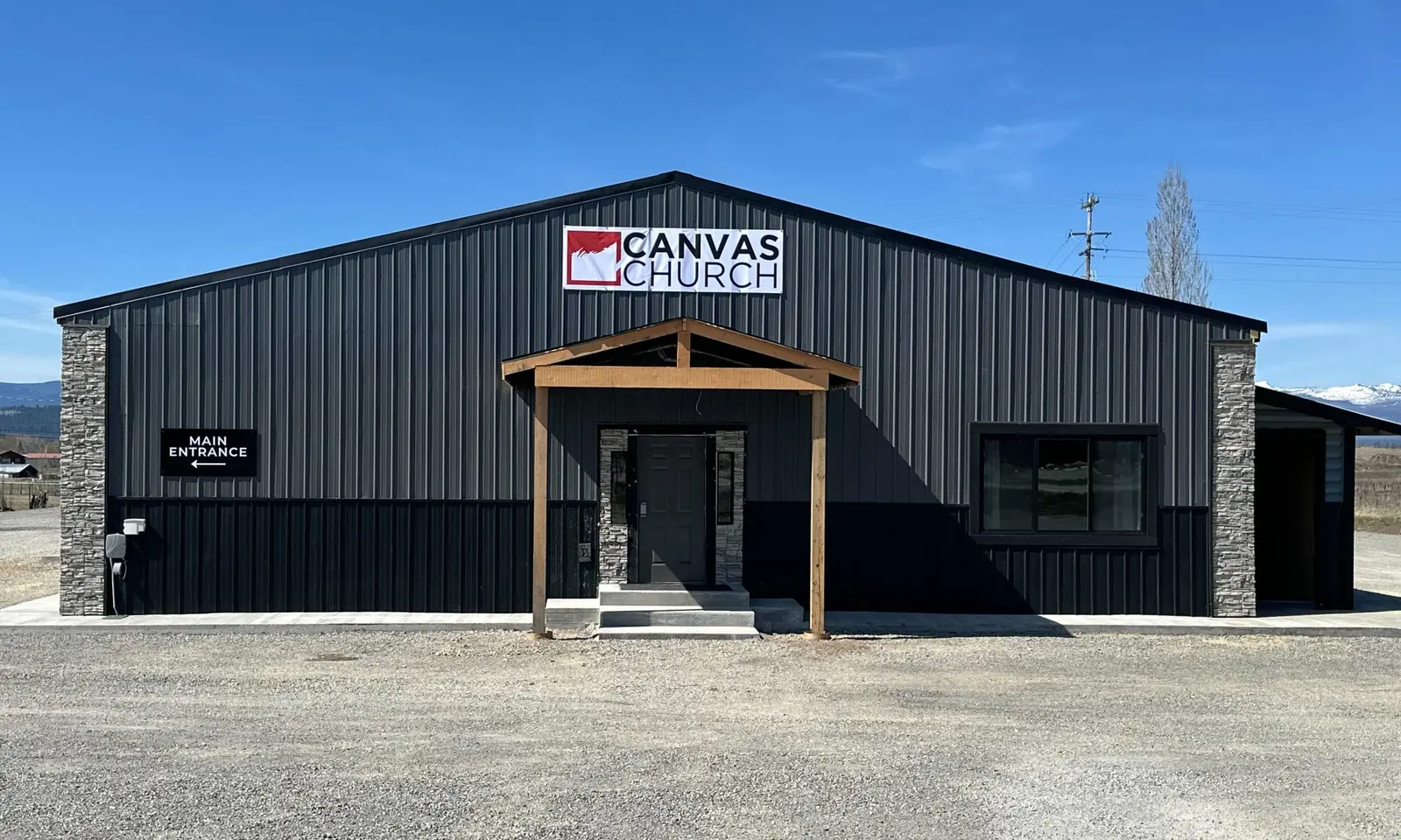 A modern building with a sign that reads Canvas Church and an entrance labeled with a main entrance sign.