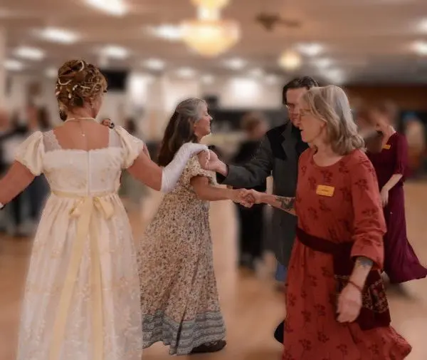 A group of adults dances in a ballroom.