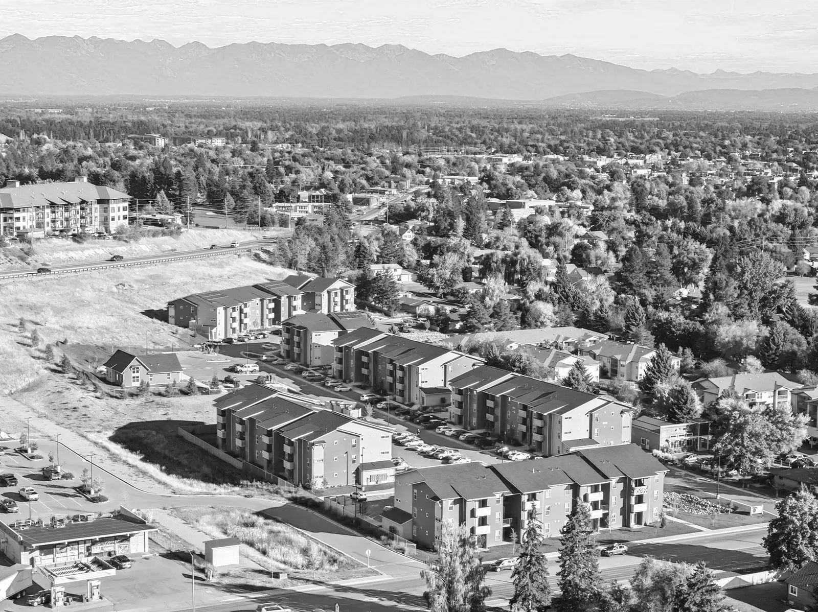 Aerial view of Junegrass place and the surrounding houses, roads, trees, and mountains in the background