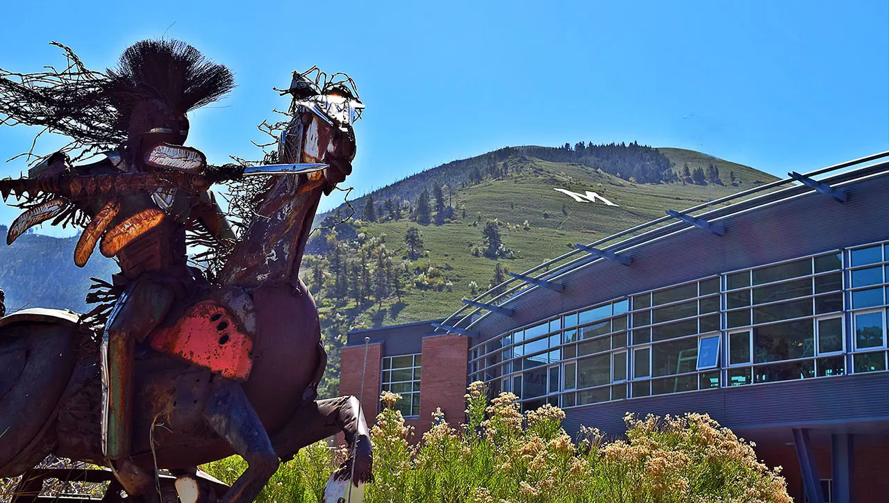 View of horse sculpture made of metal with Campus Rec building in background