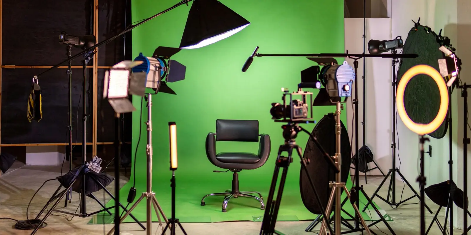 Photography studio with green screen and equipment.