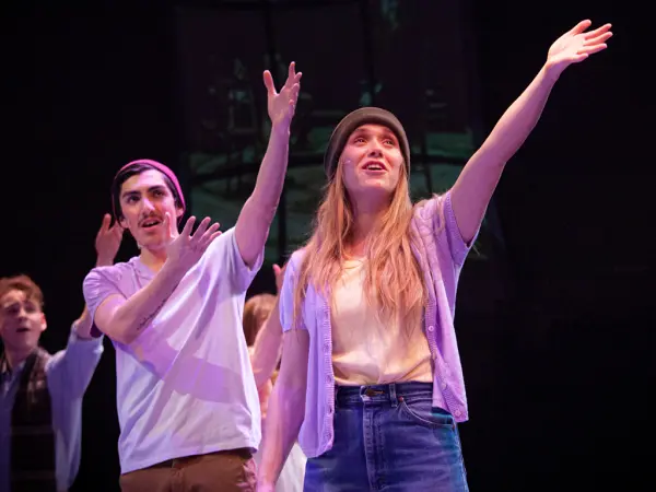 The 2020 Cast of "Spring Awakening" raising their arms in song.