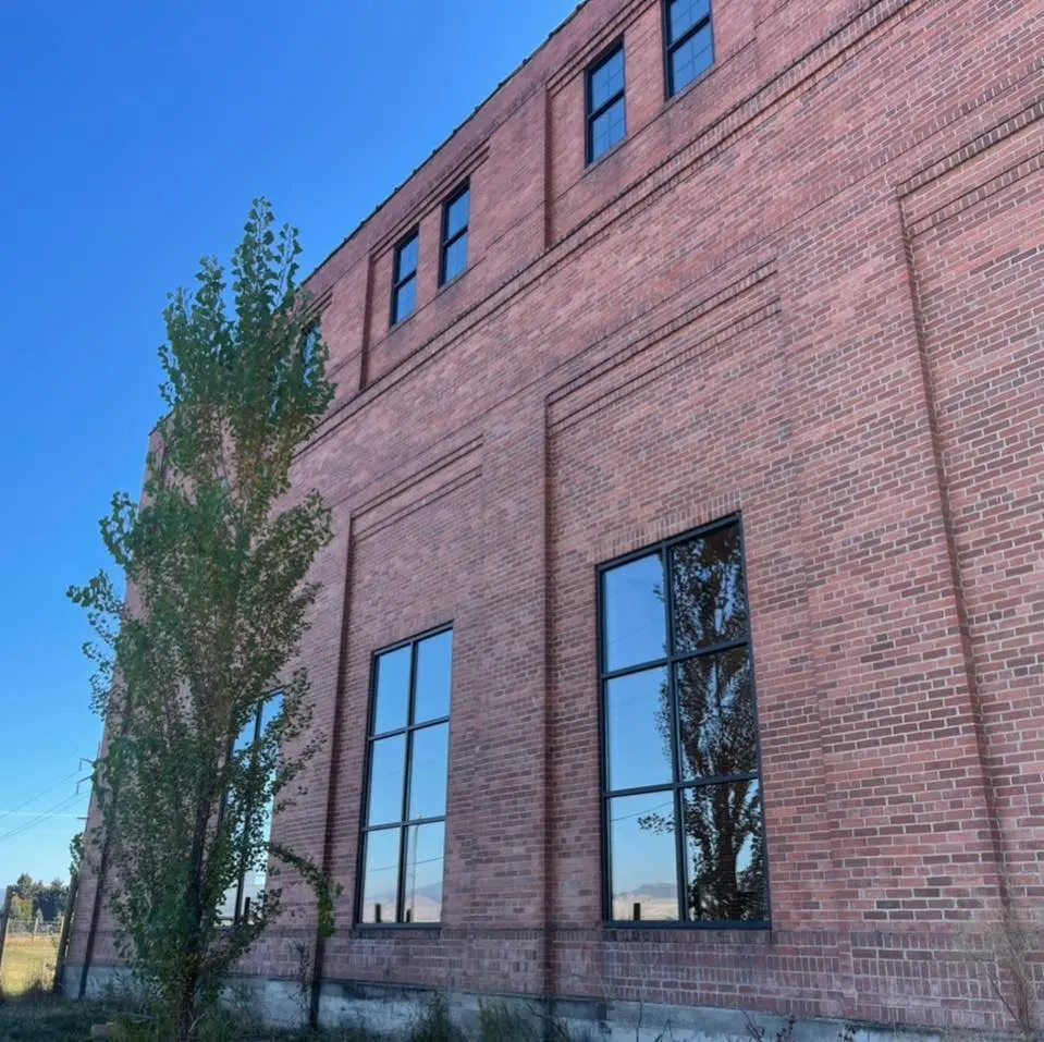 A red brick building stands against a clear blue sky.