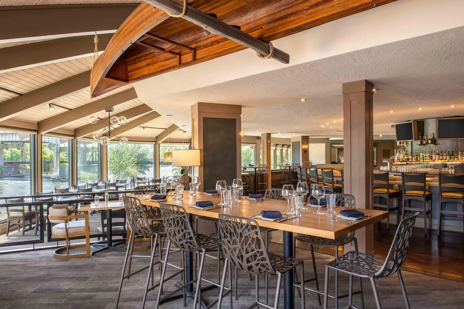 An interior view of a restaurant featuring a long wooden table and a decorative canoe suspended from the ceiling.