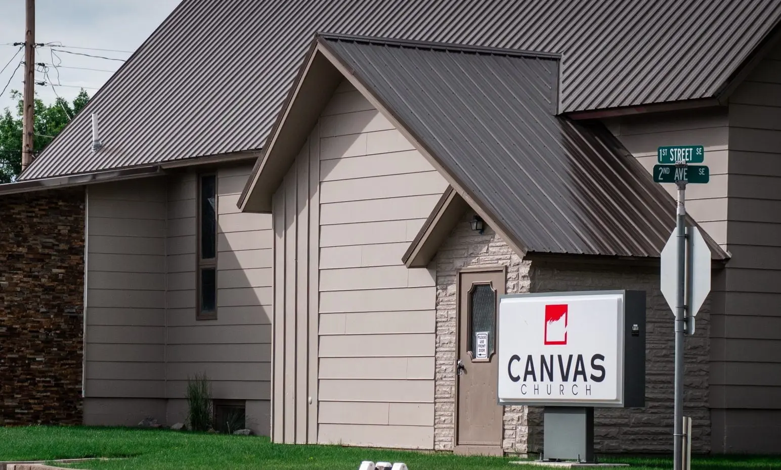 A view of a church building with a sign identifying it as Canvas Church.