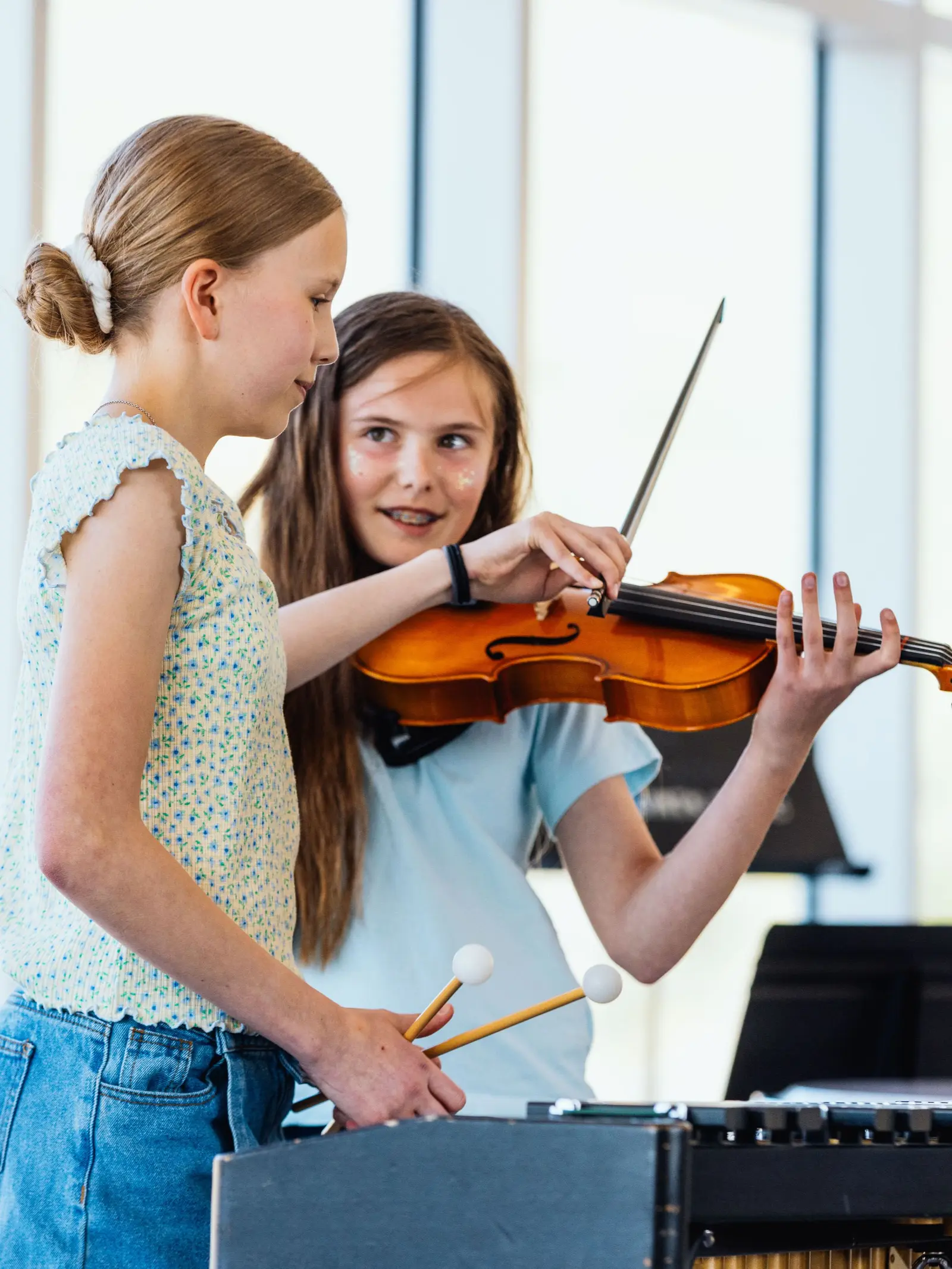 Two children are playing musical instruments together.