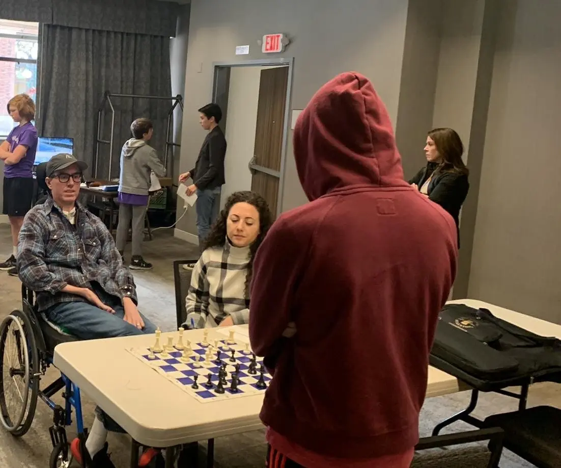 People play chess in a community room.