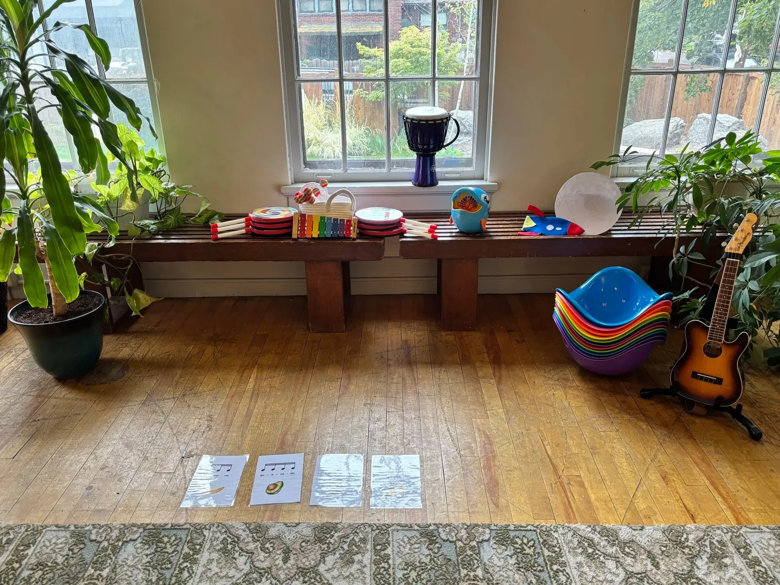 A collection of musical instruments and educational cards are arranged in a sunlit room.