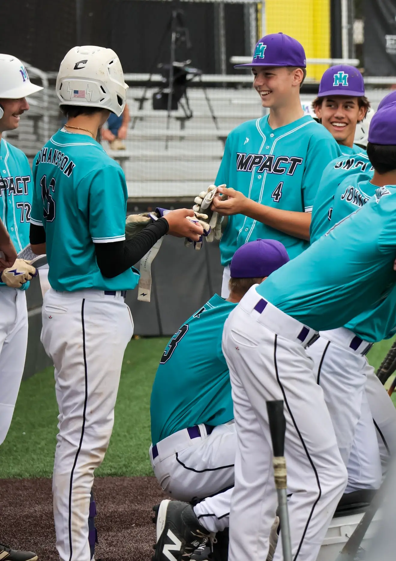 A team of young baseball players in teal and purple uniforms gather on the field.