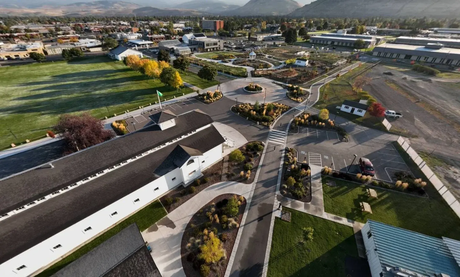 An aerial view shows a large building and surrounding grounds with walkways and landscaping.