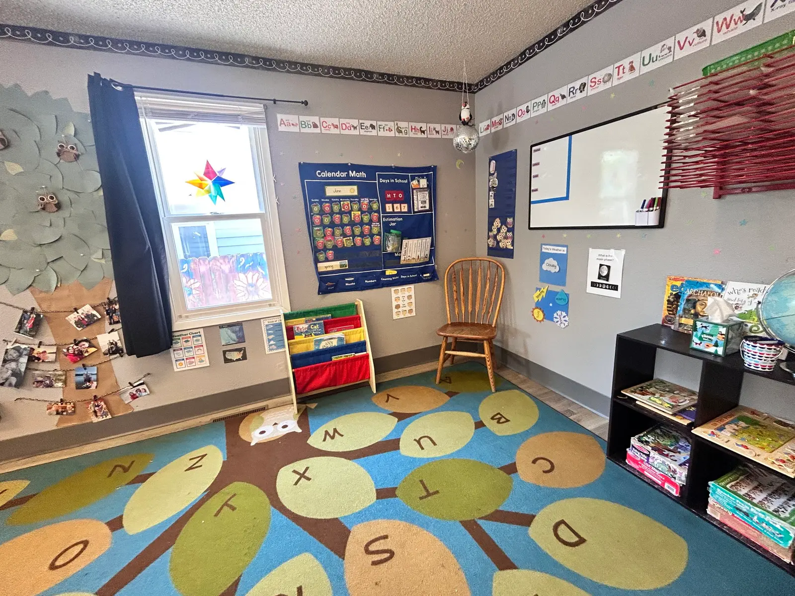 A photo of an educational room set up for children with alphabet letters, learning charts, and books.