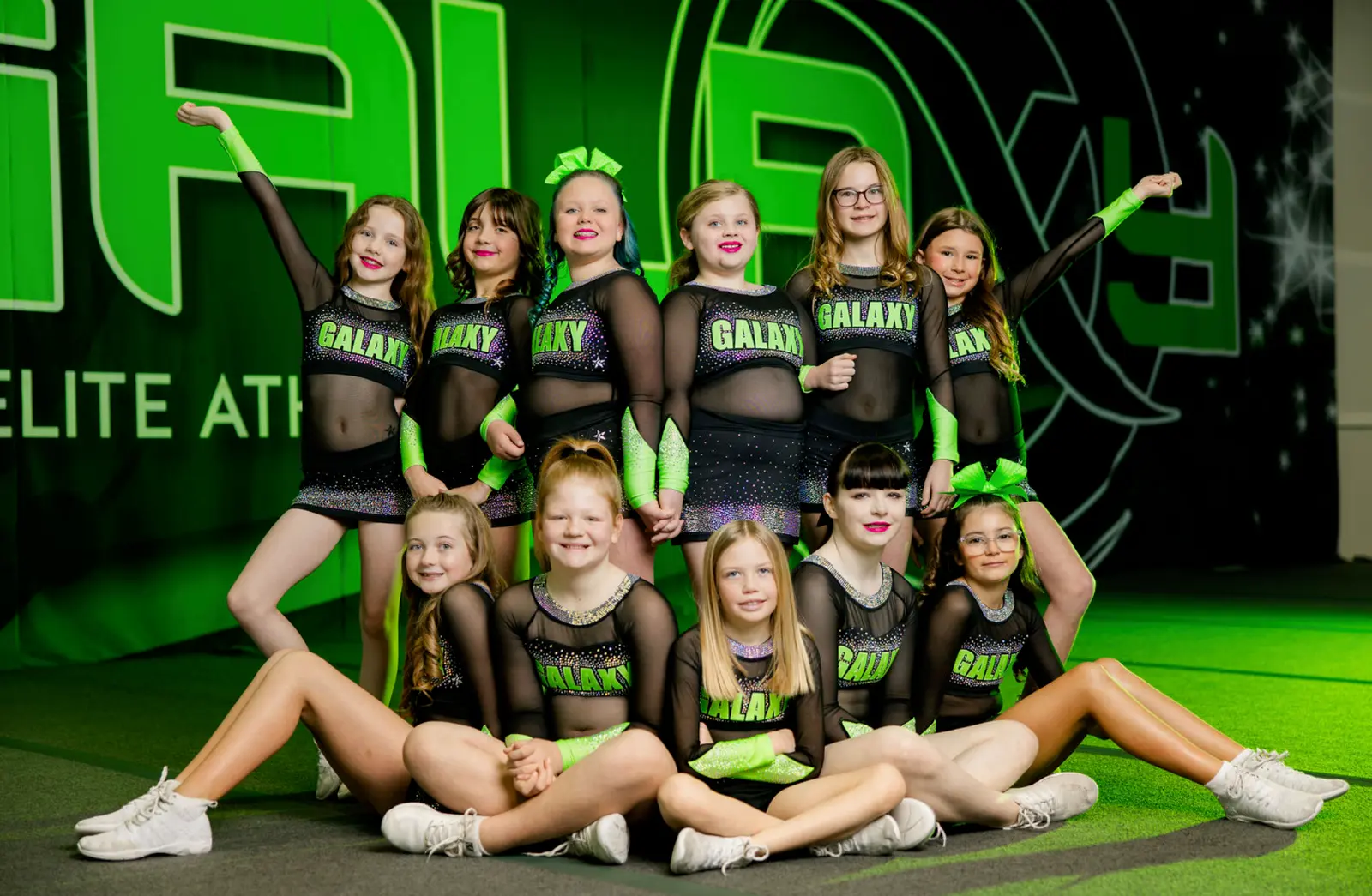 A group of young cheerleaders in uniform poses for a team photo.
