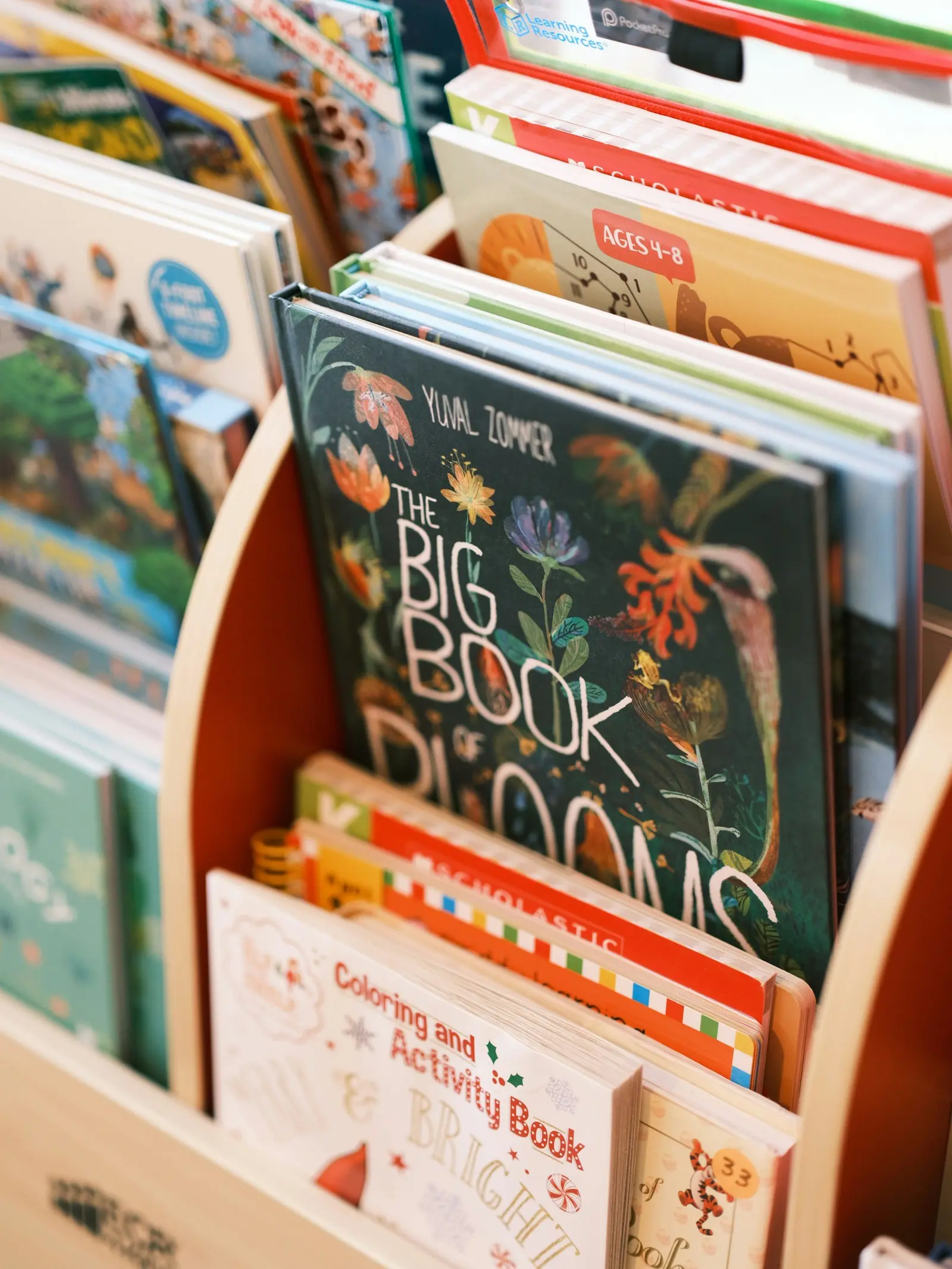 A wooden bookshelf filled with various children's books.
