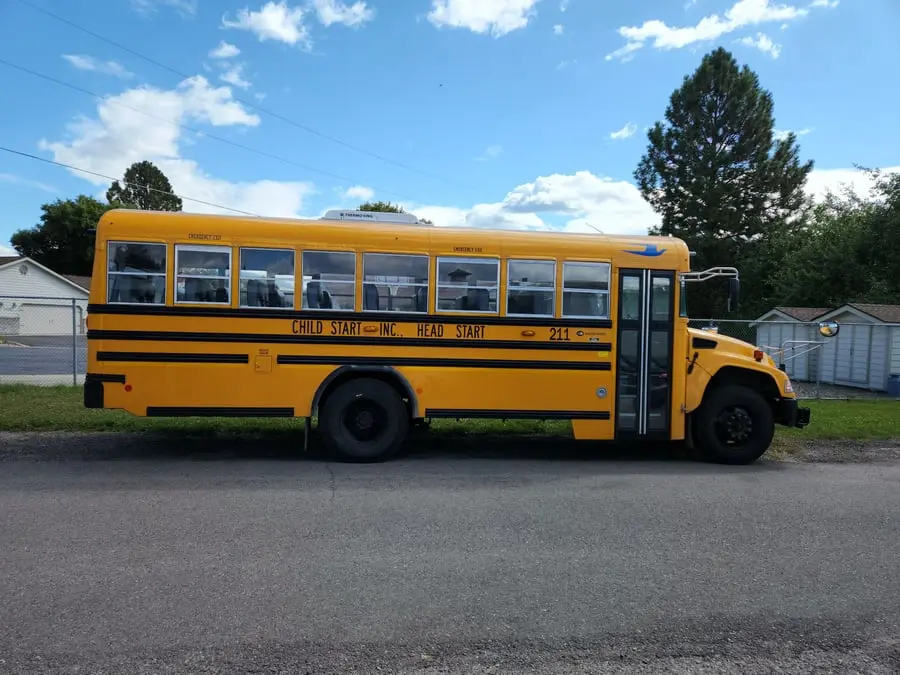 A yellow school bus is parked on the side of a road.