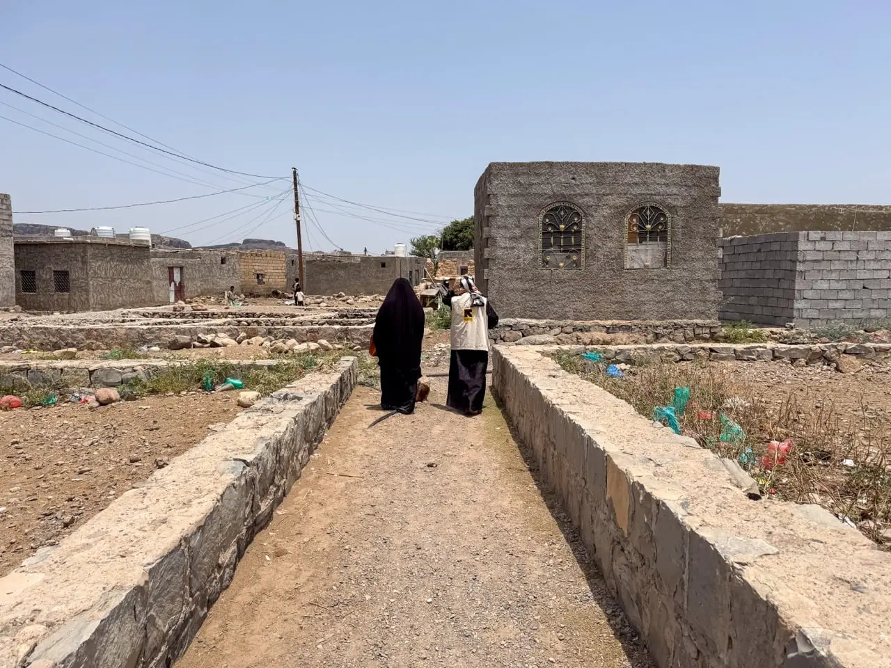 Basma walks with an IRC staff member
