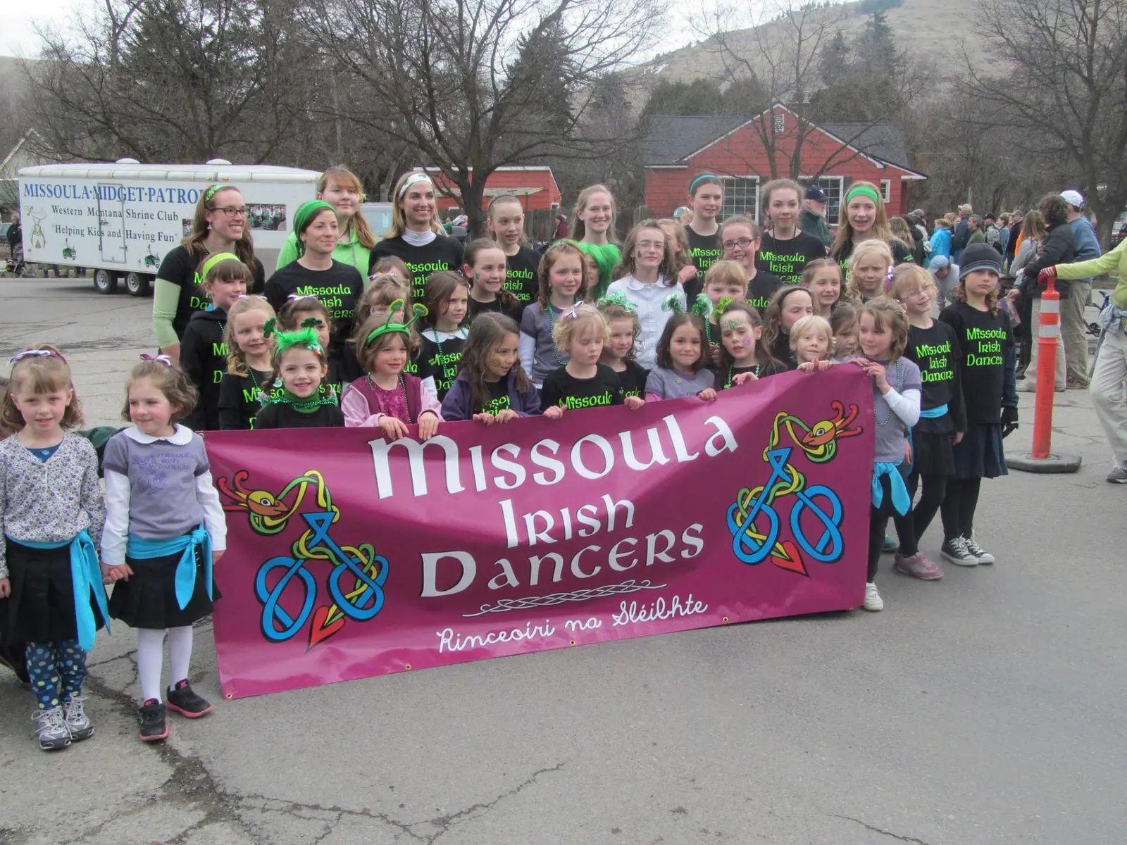 A large group of children and adults posing with a banner for the Missoula Irish Dancers.