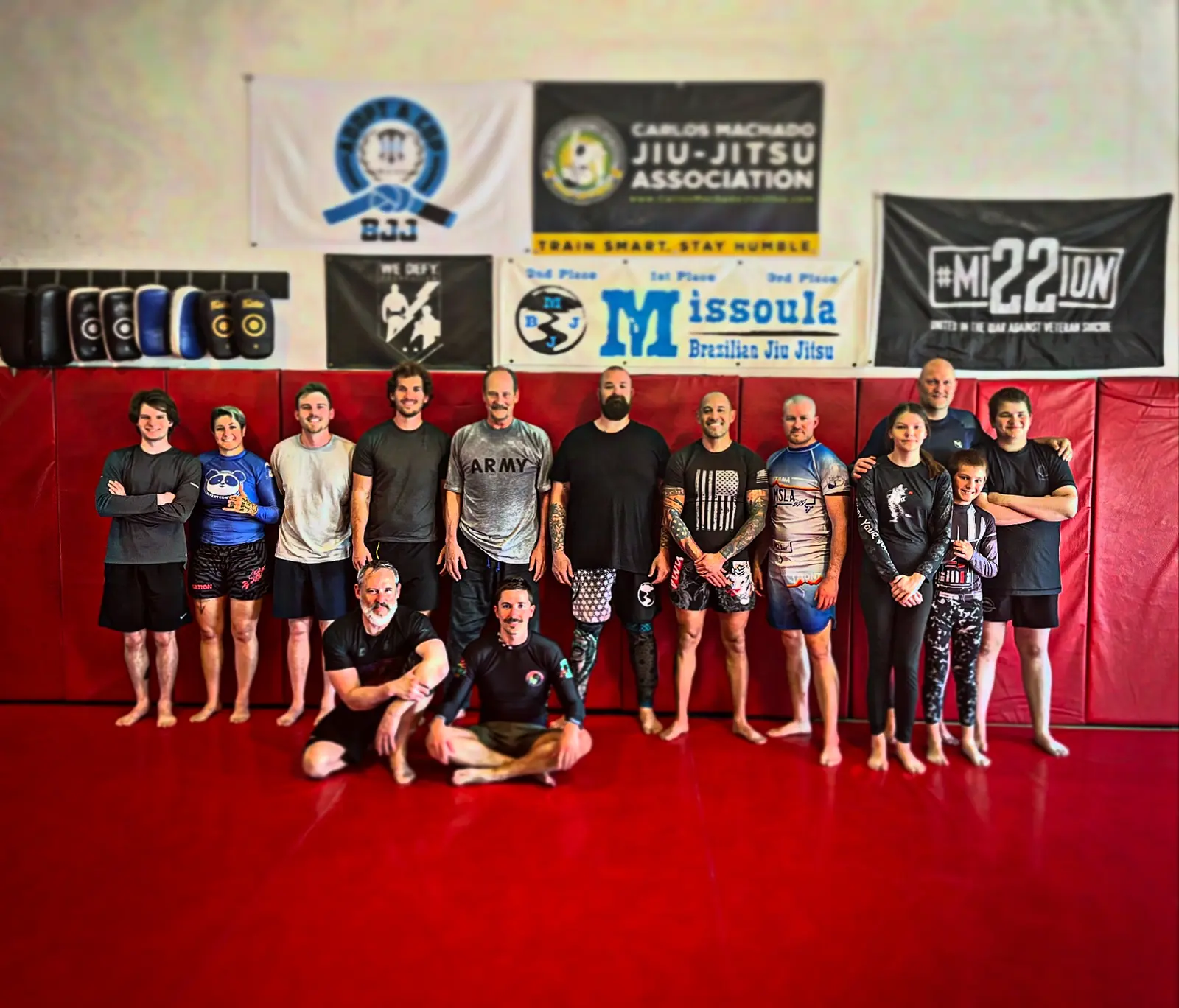 A group of people poses for a picture in a martial arts gym.