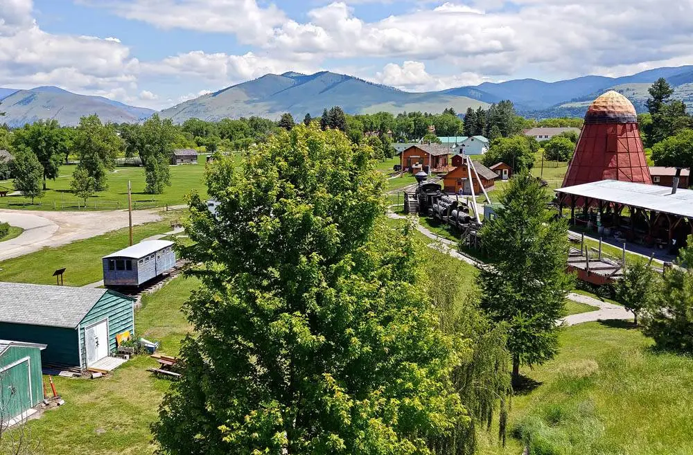 A scenic view of a historical railroad site with old buildings and mountain vistas.