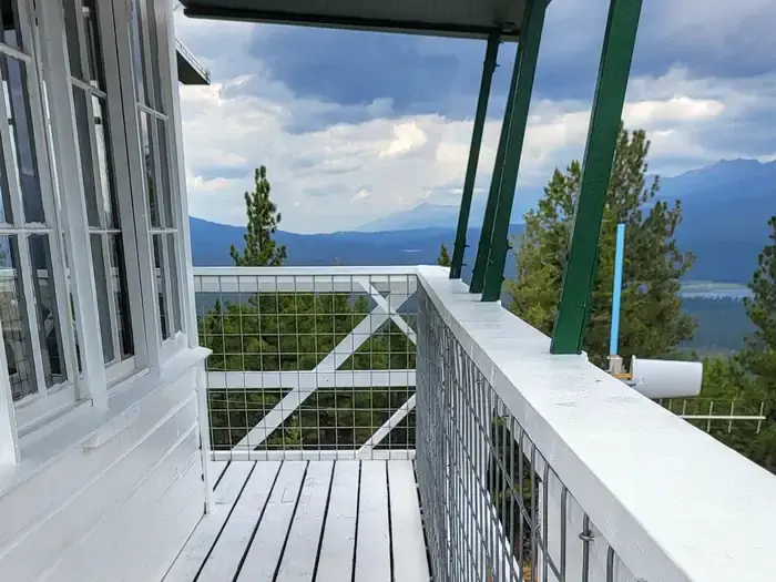 Double Arrow Lookout Tower- Exterior deck facing North to Seeley Lake water body and Richmond Ridge Mountains. Cotton Candy colored clouds during sunset.Double Arrow Lookout Tower- Catwalk facing North to Seeley Lake water body and Richmond Ridge Mountains. Cotton Candy colored clouds during sunset.