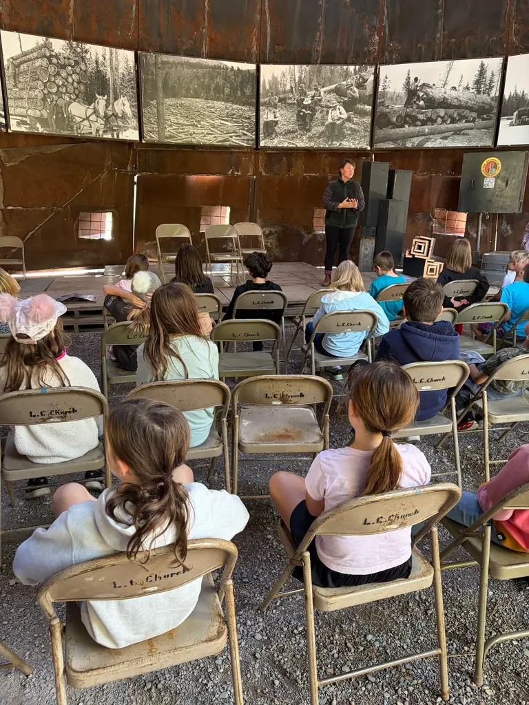 Students are watching a presenter speak about bats in Montana.