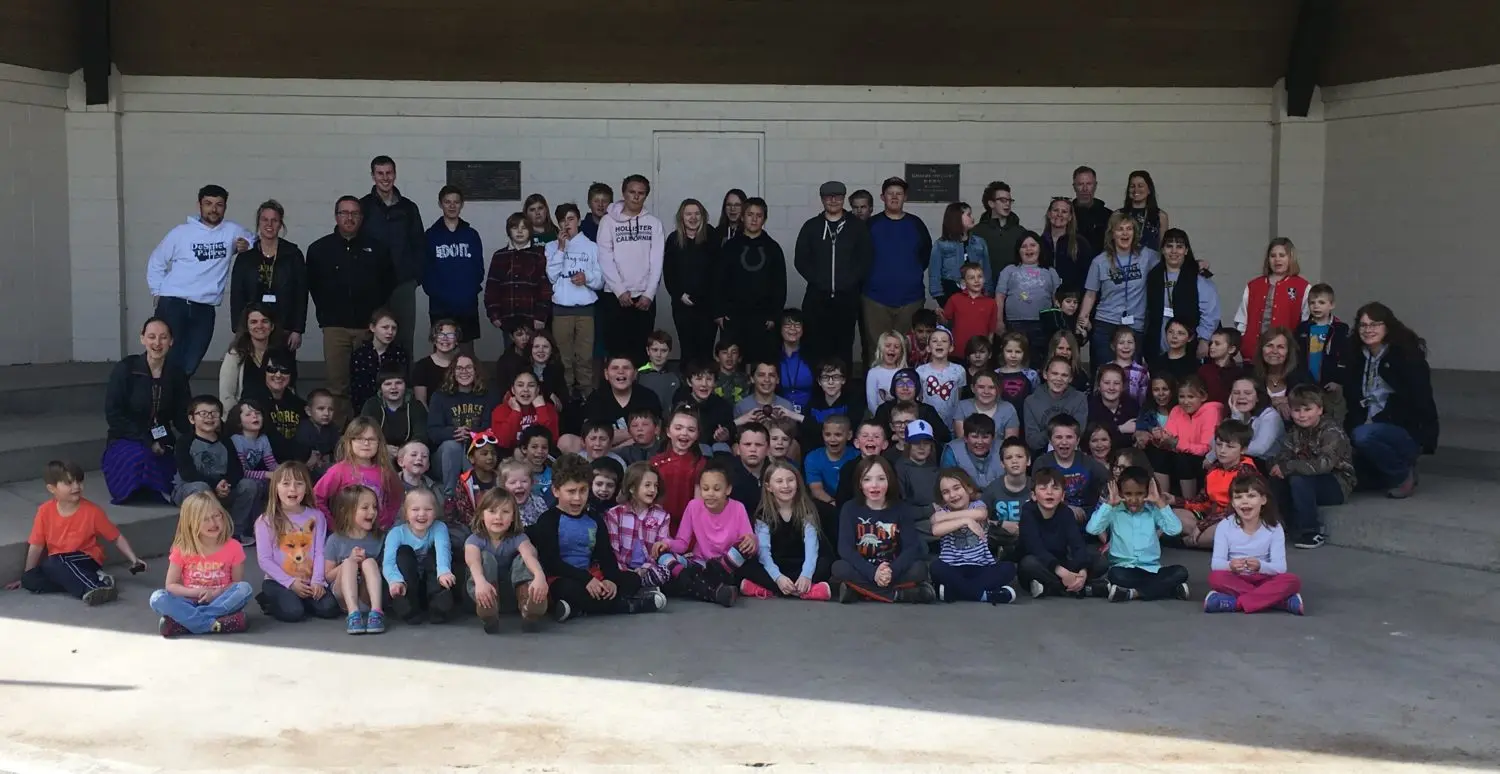 A large group of children and adults pose for a photograph together.