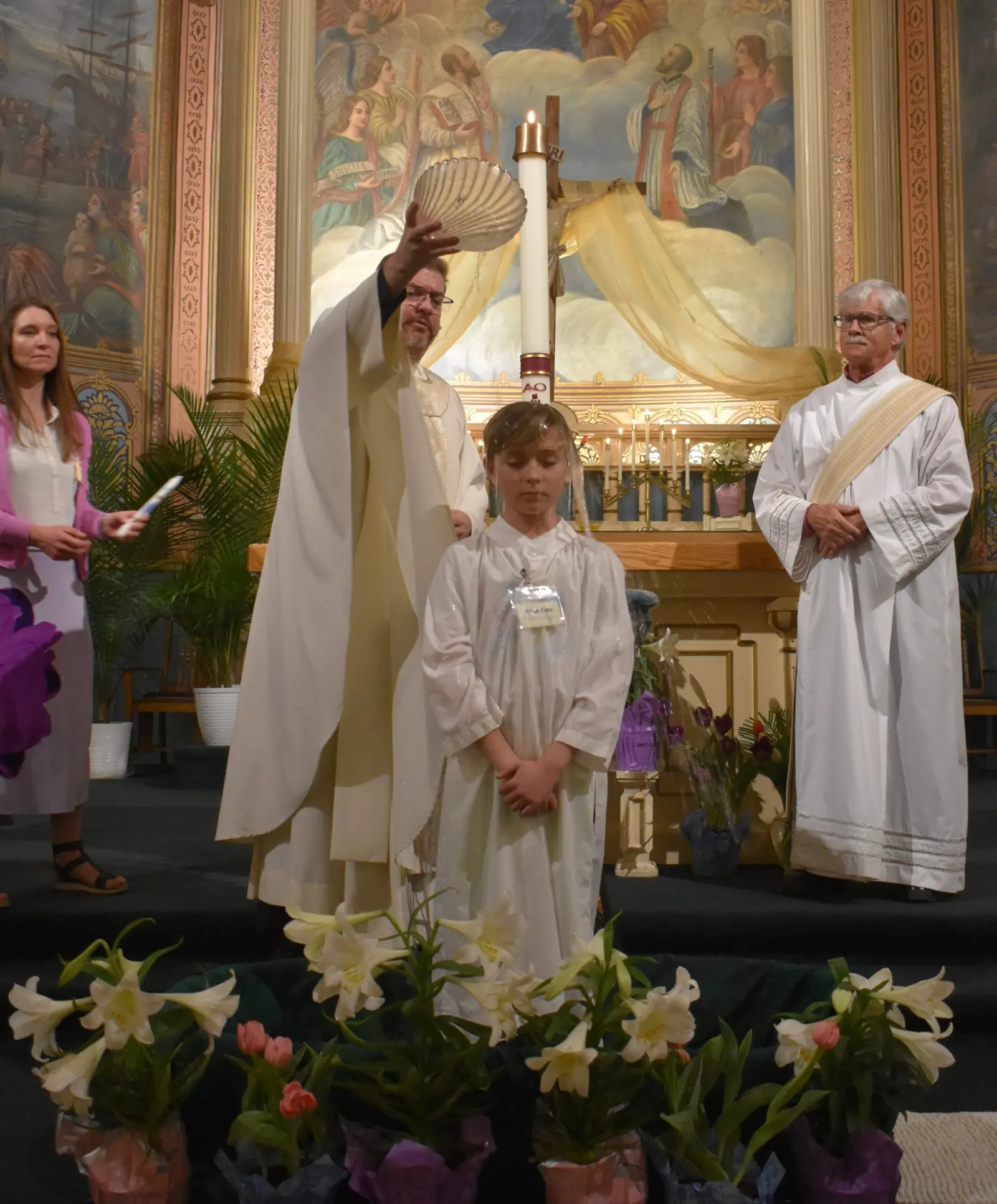 A child is being baptized in a church by a clergy member.