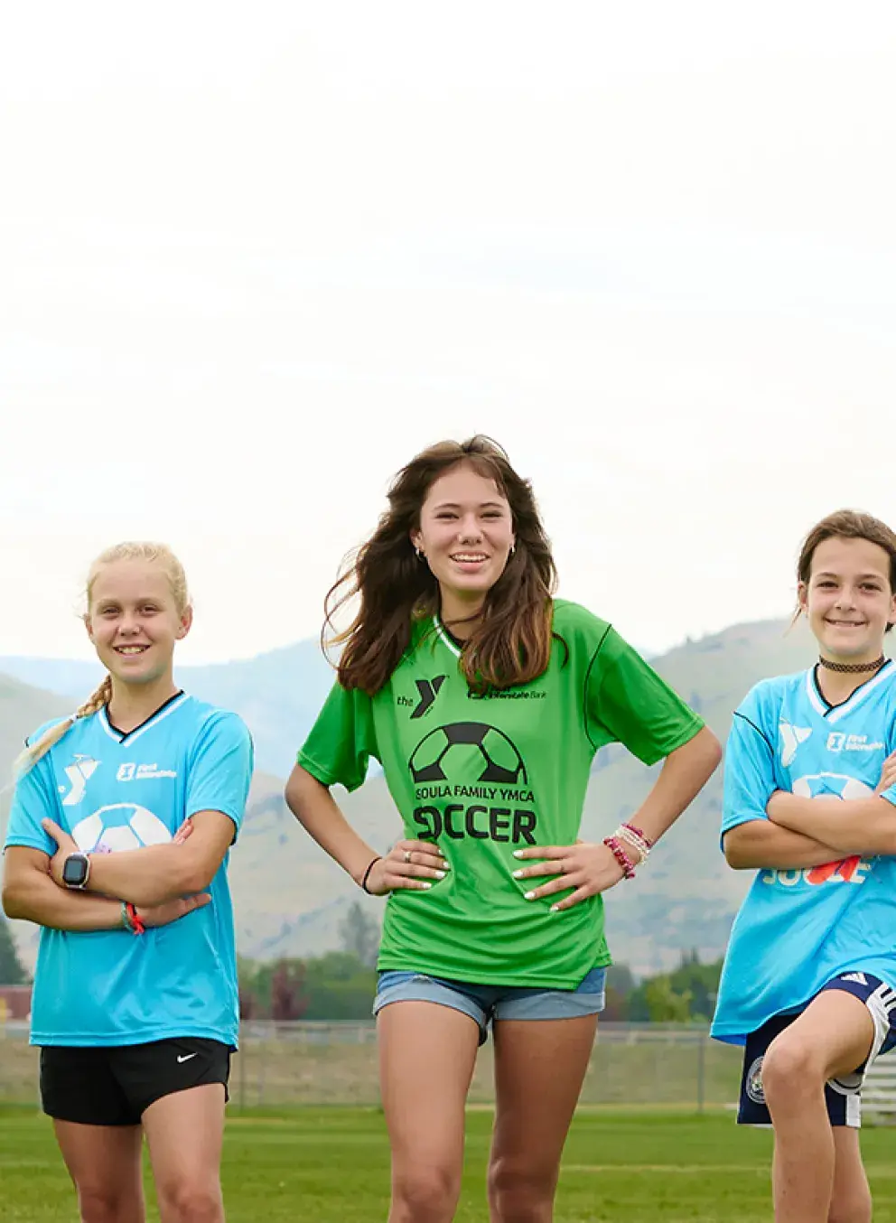 two teen soccer players in green jerseys and two players in blue jerseys during a missoula ymca soccer practice