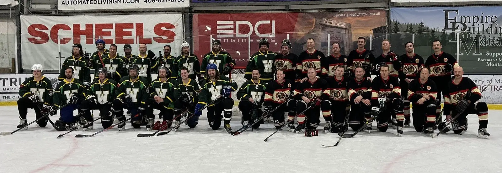 A group of adult ice hockey players in team jerseys poses for a photo on an indoor rink.