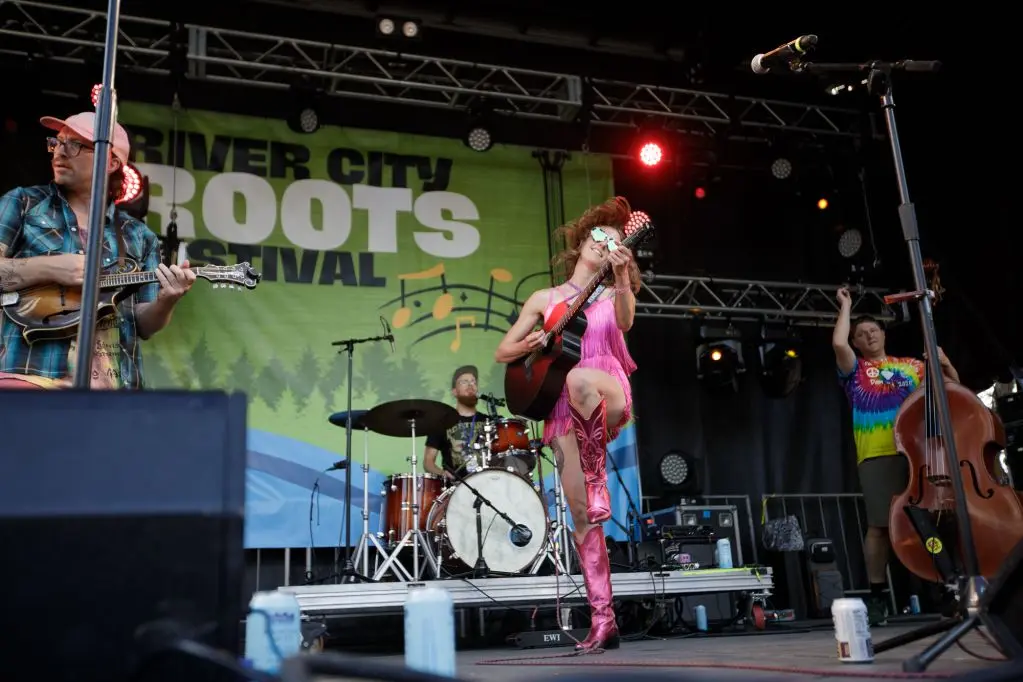 A band performs on a stage during an outdoor festival.
