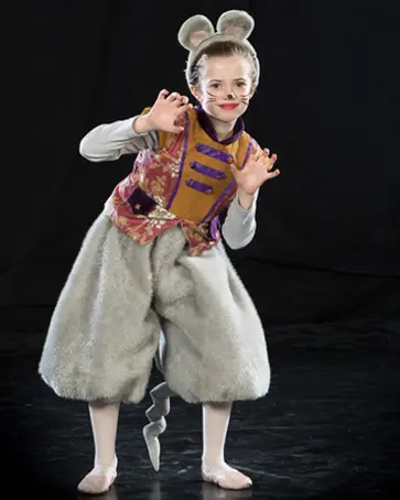 A child wearing a mouse costume poses with their hands up.