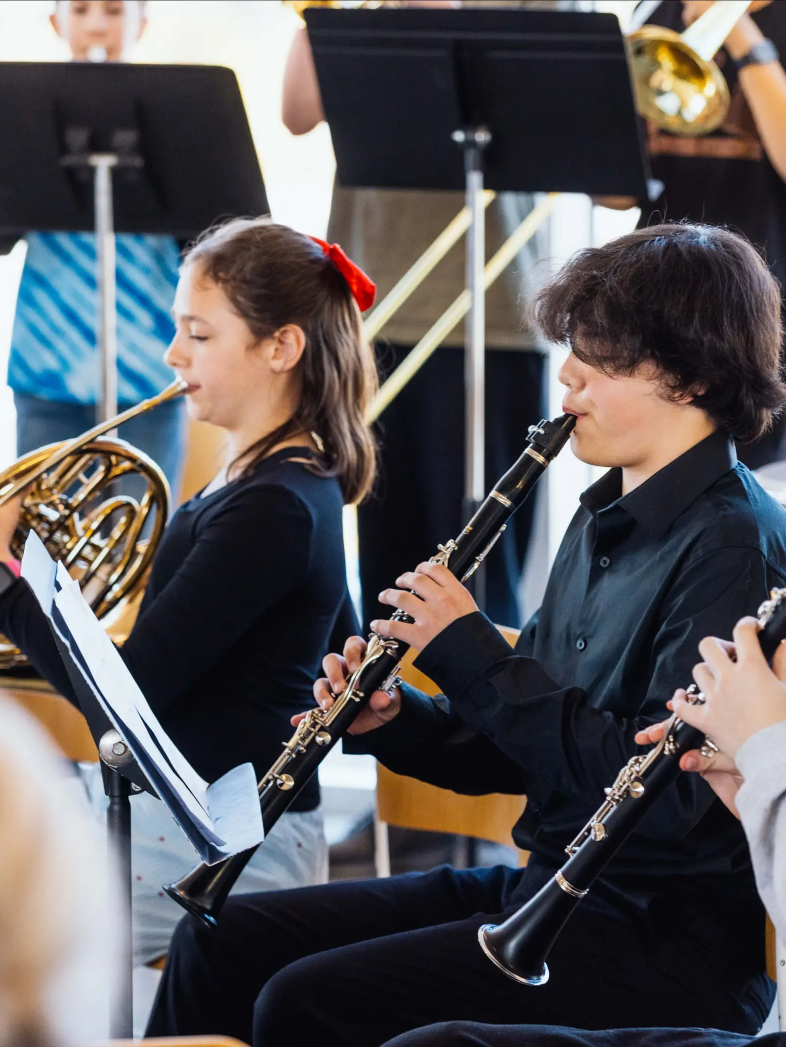Students play musical instruments together in an ensemble.