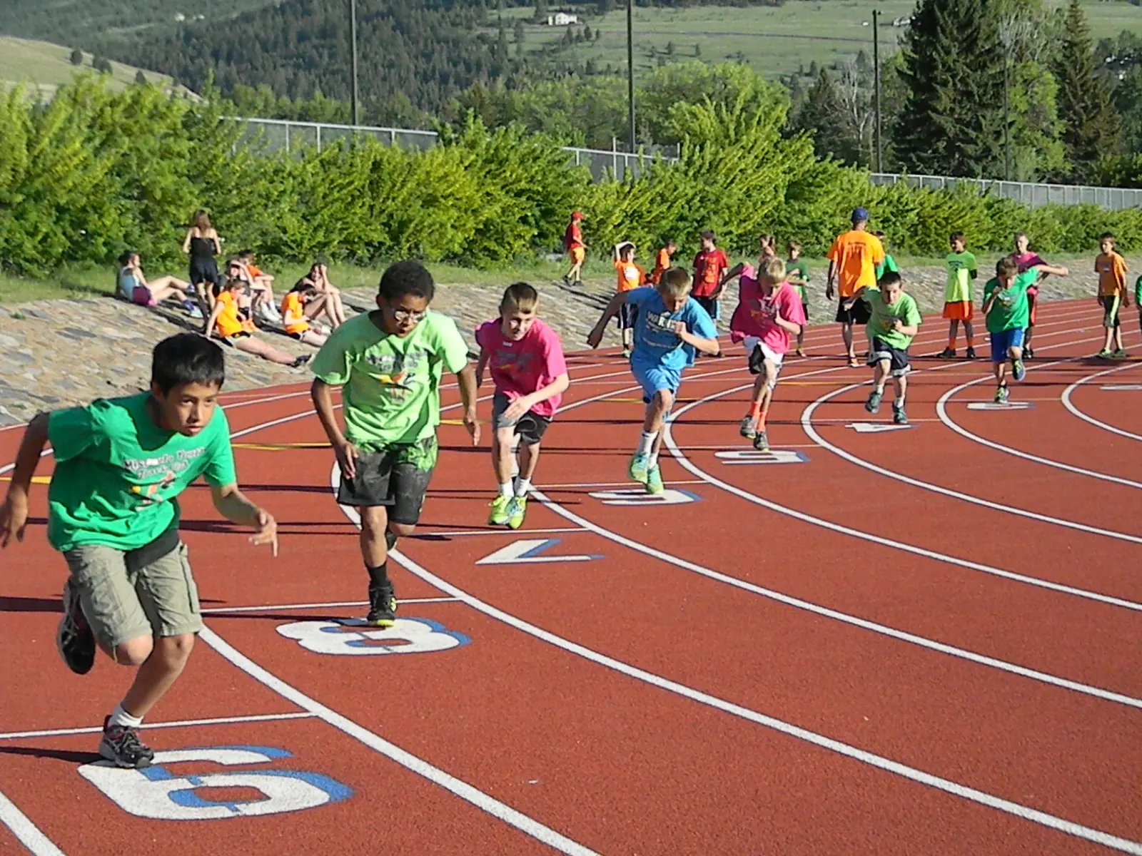 A group of children are participating in a running race on a track.