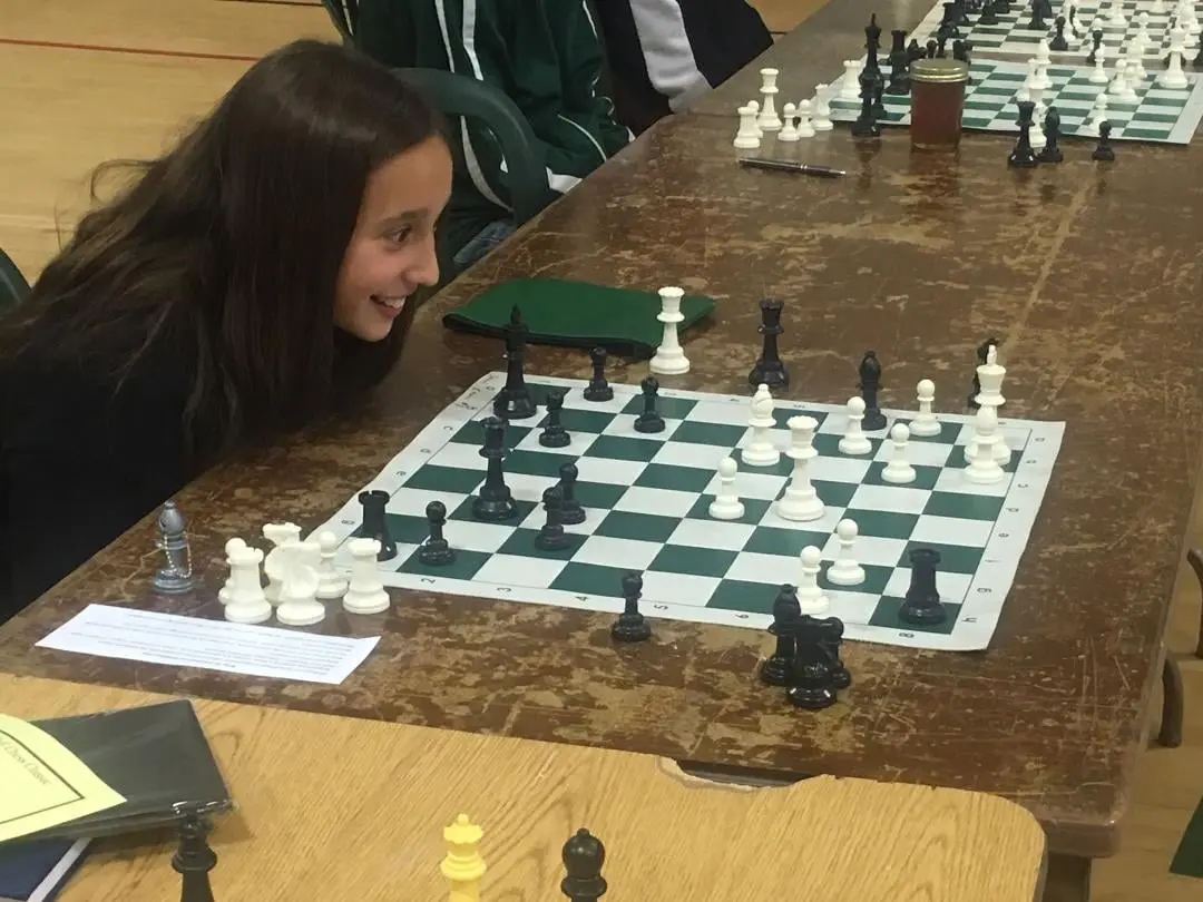 A girl plays a chess game at a tournament.