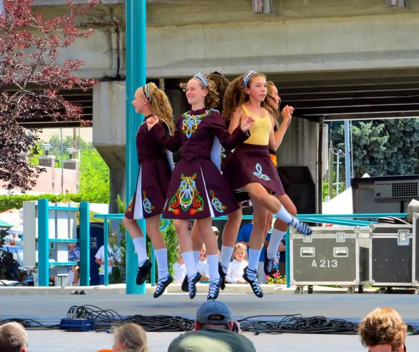 A group of Irish dancers performs on an outdoor stage.