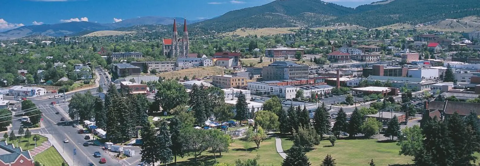 A wide-angle aerial view of a town nestled in a valley with mountains in the background.