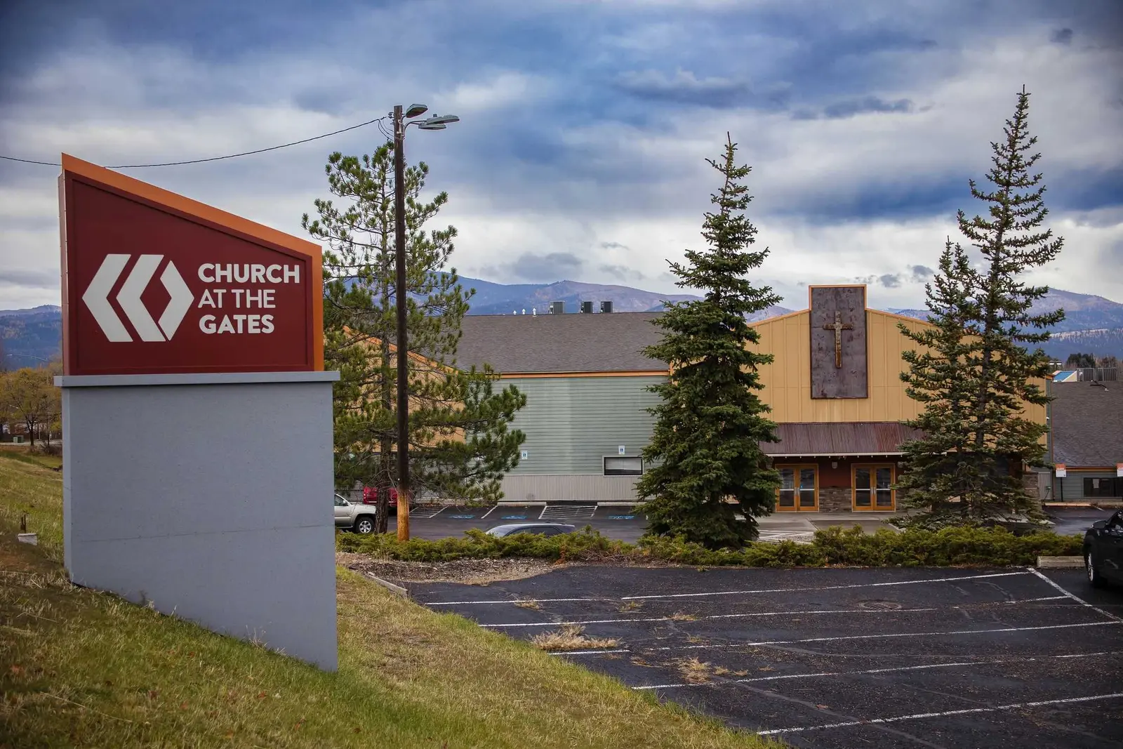 A church building is shown behind a sign displaying its name.