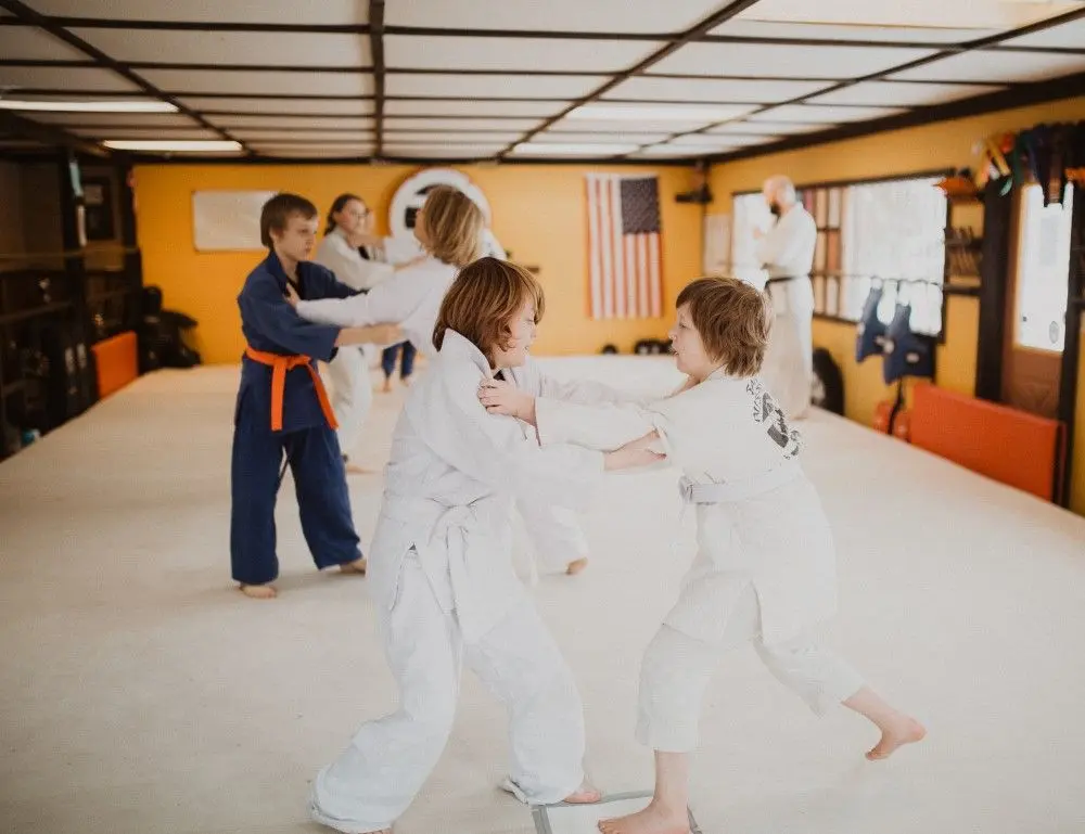 Children participate in a martial arts class at a training studio.