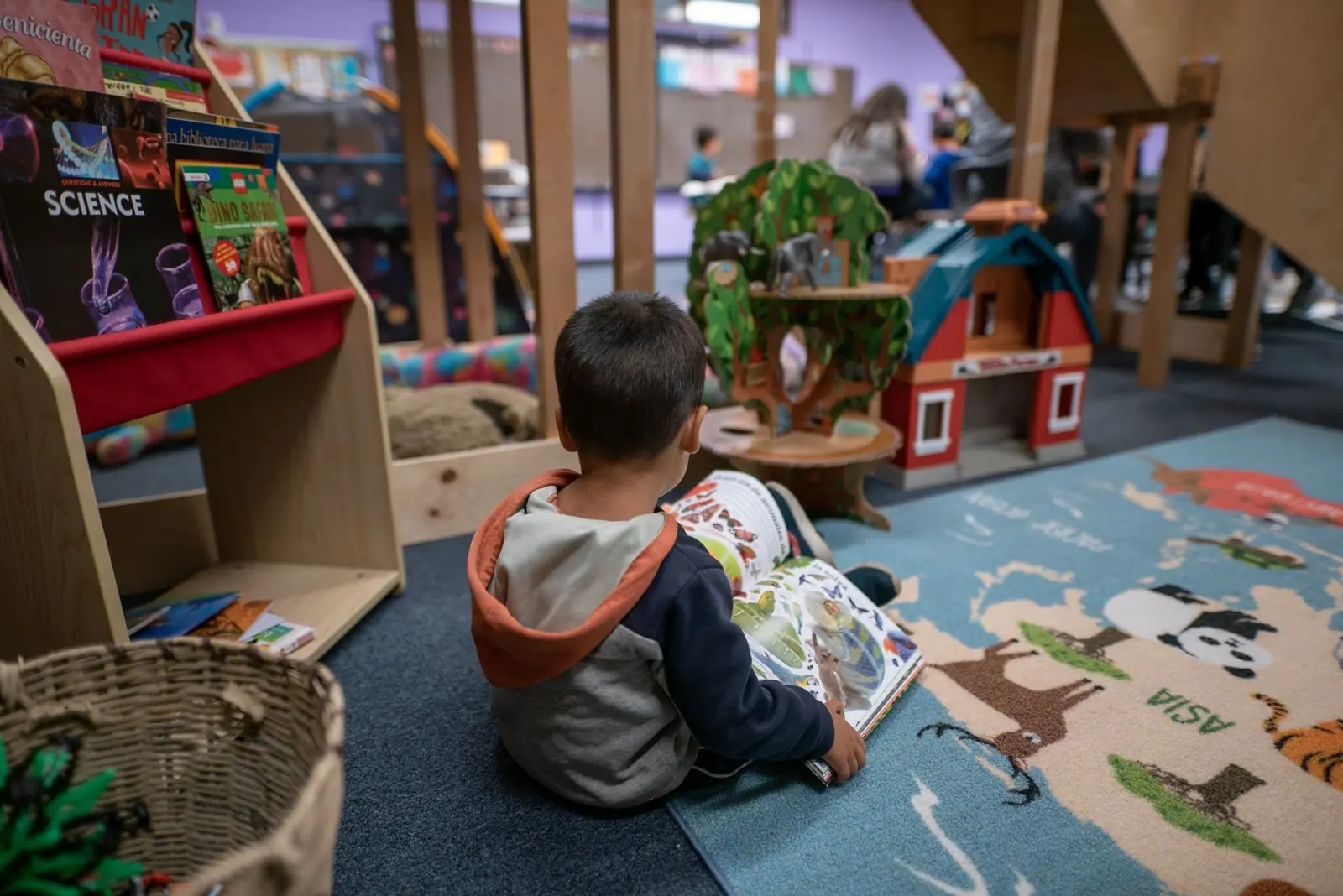 A young boy reads a book by himself at the IRC's Welcome Center in Phoenix, Arizona.