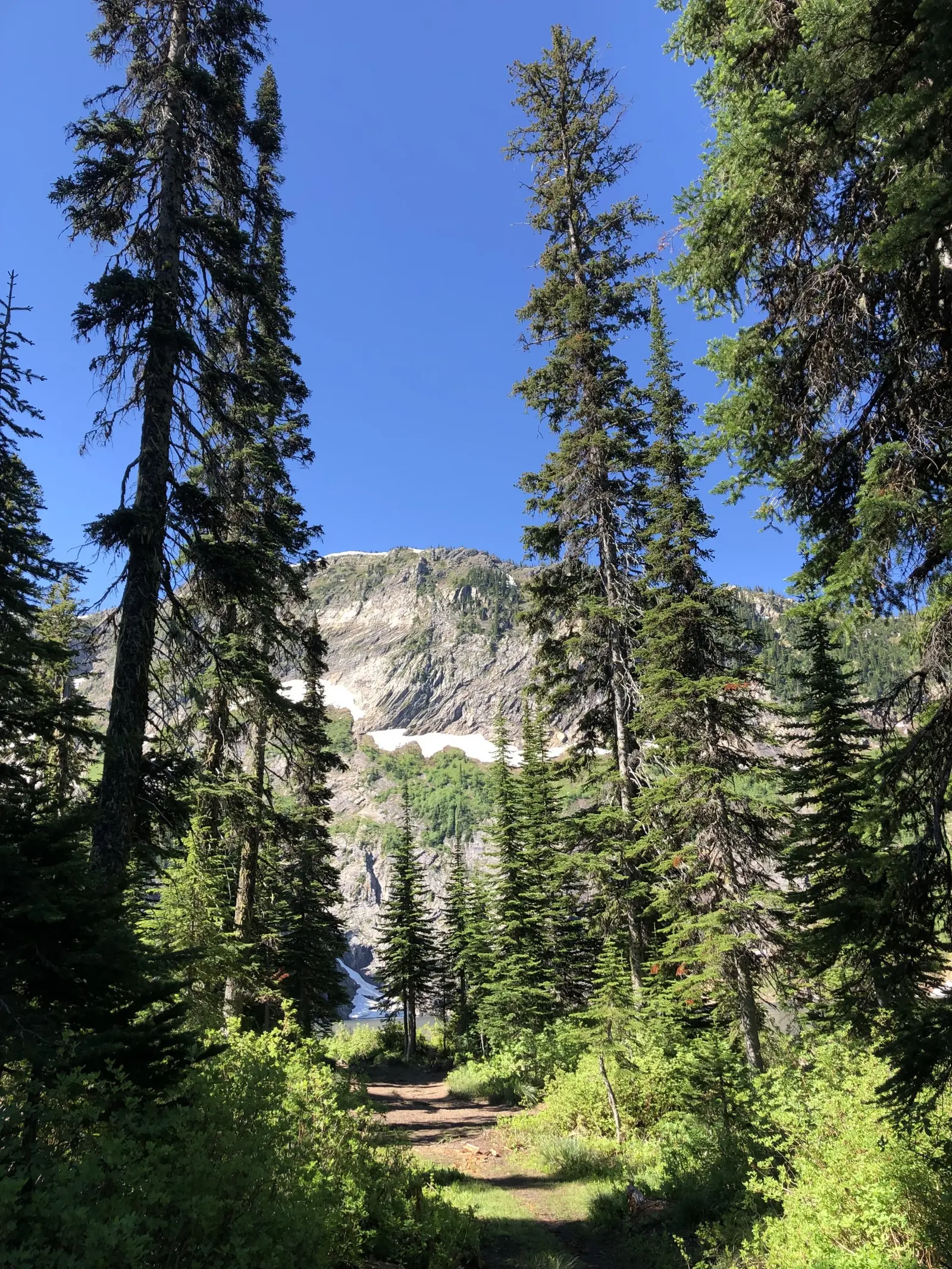 Trail with a lake and a cliff in the background
