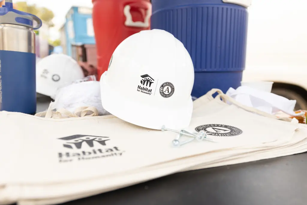 A hard hat and construction supplies are displayed on a table.