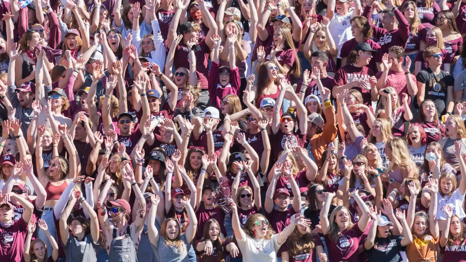 A large crowd of people with their hands raised in the air.