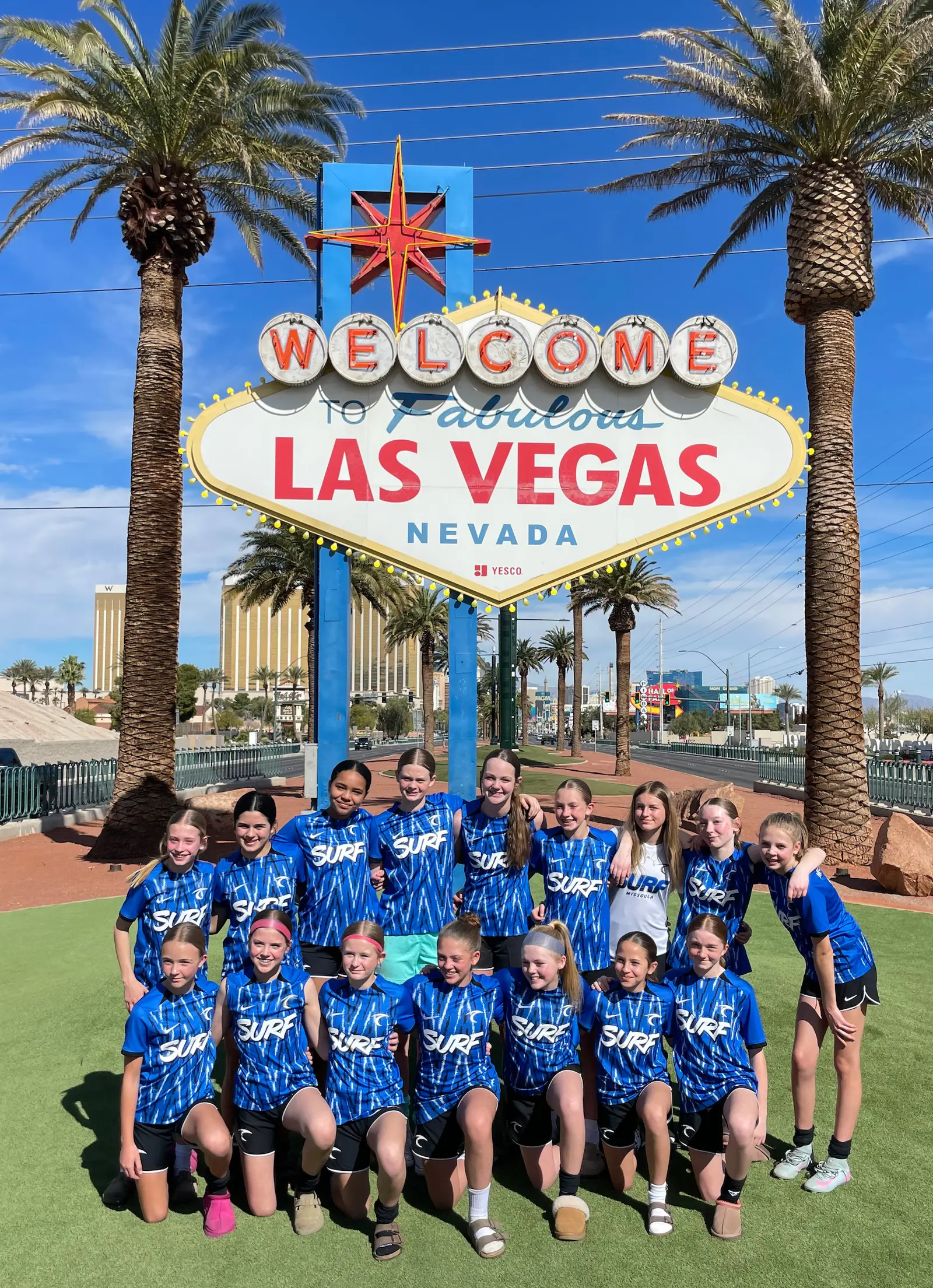 A group of young soccer players poses in front of the Welcome to Fabulous Las Vegas sign.