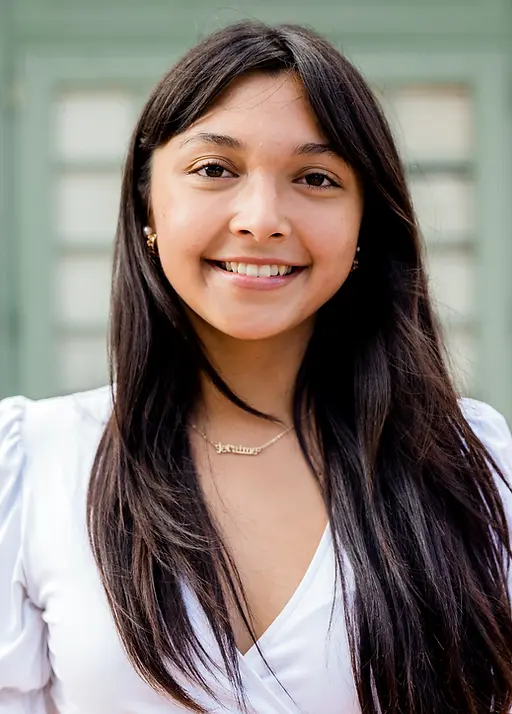 latina woman smiling in front of green background