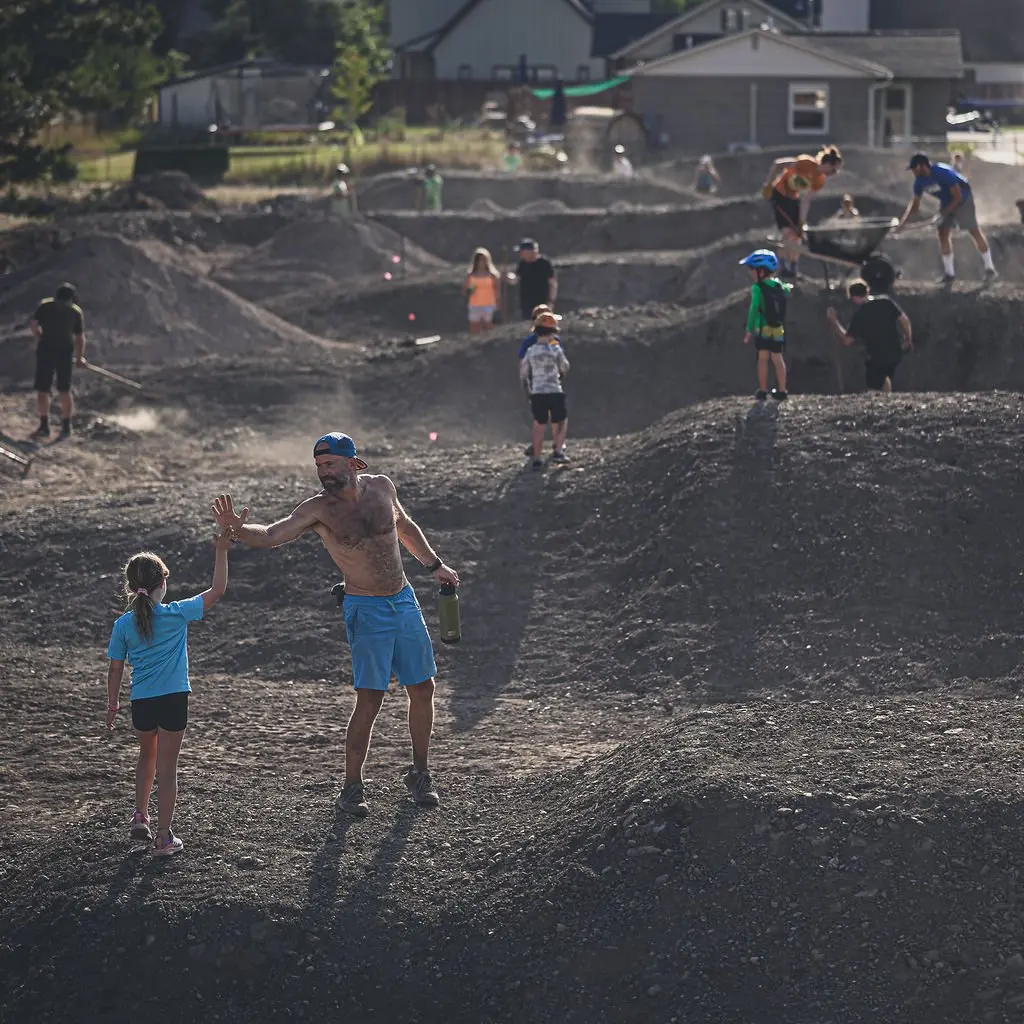 A group of volunteers work together to build a dirt trail.