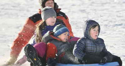Photo from missoulian.com A family sleds down a snowy hill together.