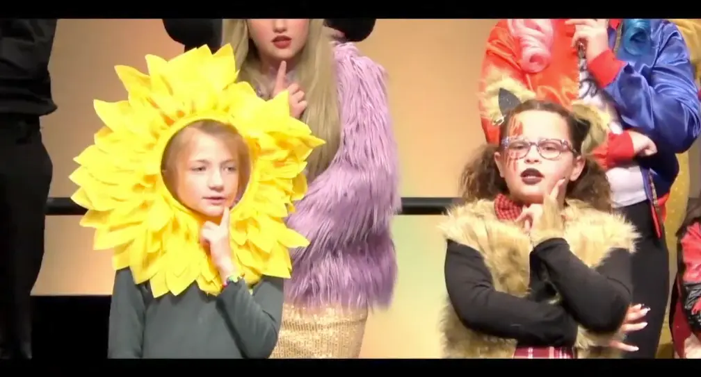 Children dressed in costumes and makeup, participating in a school play or costume event.